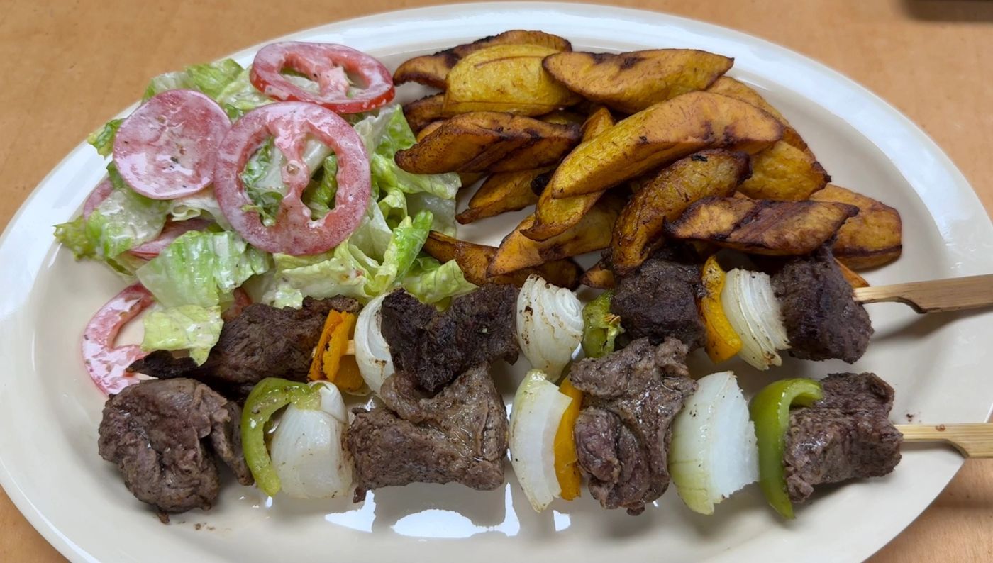 Grilled beef skewers with fried plantains and fresh salad from Restaurant Gaï
