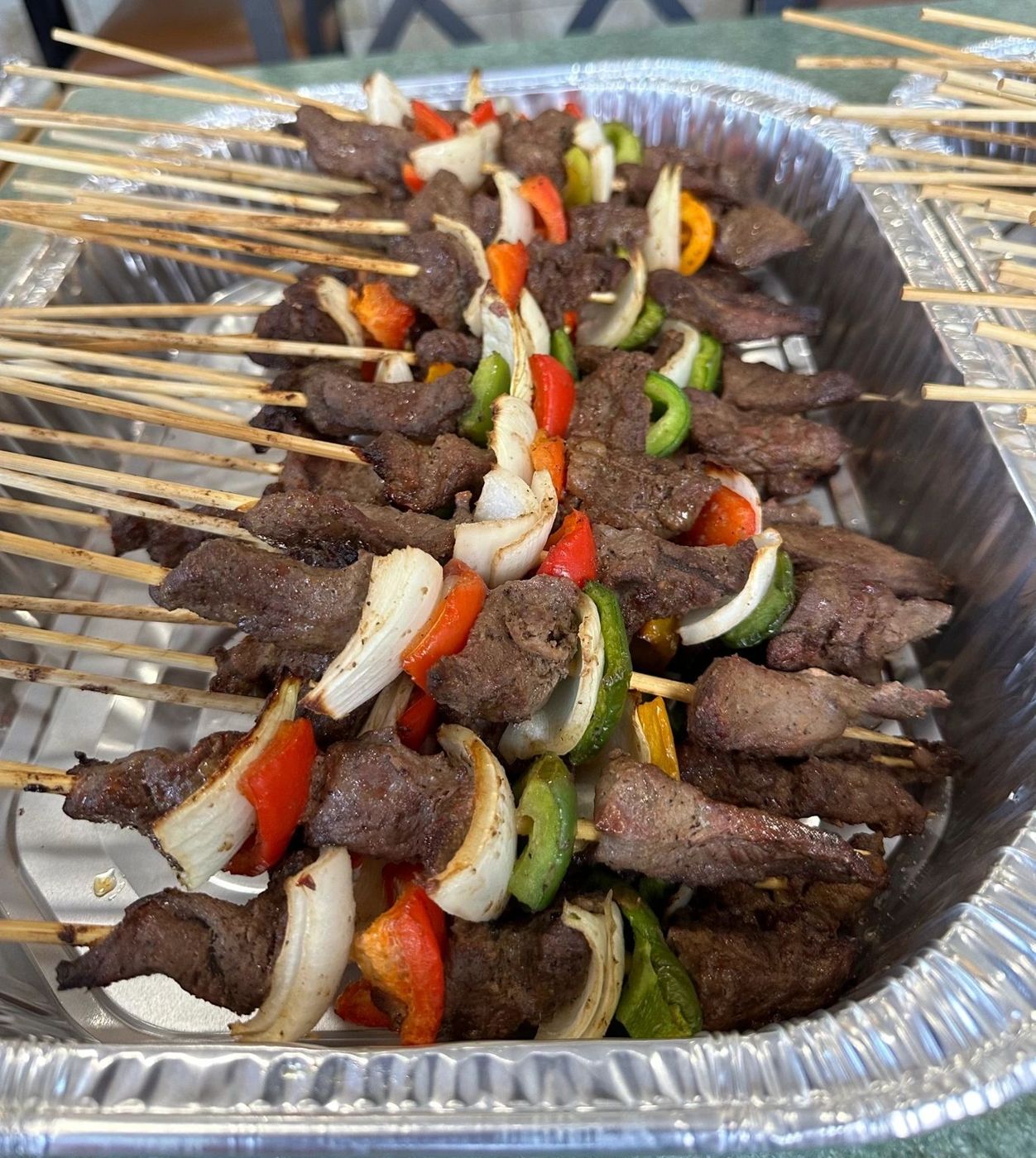 Tray of beef skewers with bell peppers and onions