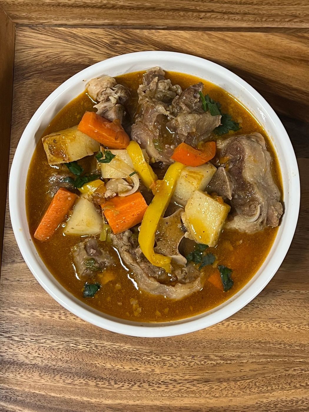Bowl of meat and vegetable soup with carrots and potatoes